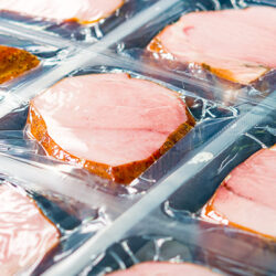 Several chunks of raw meat being processed packaged and shipped